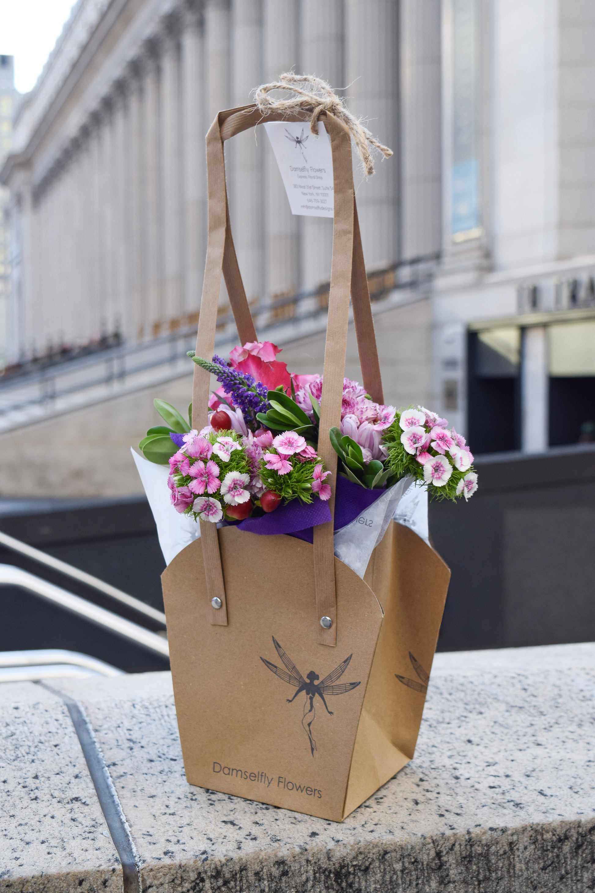 baby bouquet in damselfly packaging staged outside moynihan train hall in nyc