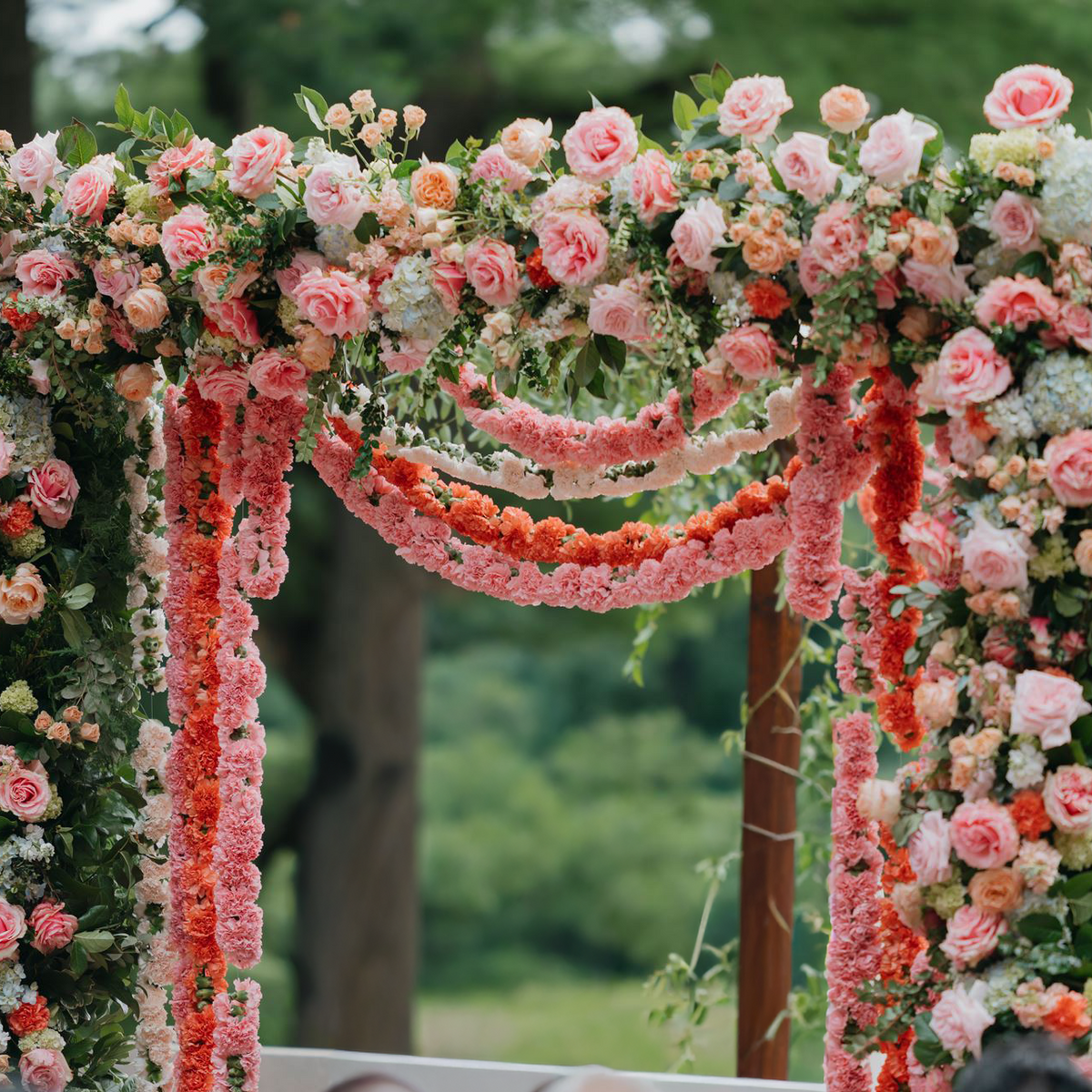 Wedding arch with blush and cream
 roses and pink carnation garland
