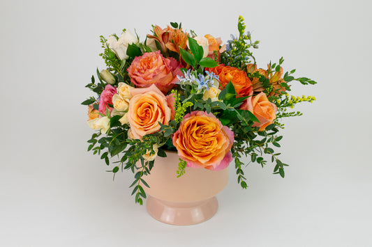 Bouquet of flowers in a pink vase on a white background