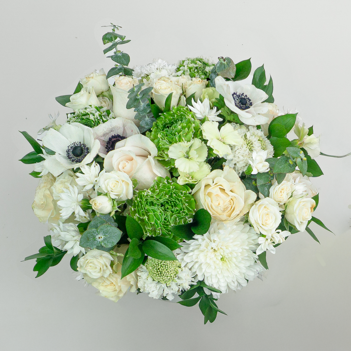 Bouquet of white and green flowers on a light gray background